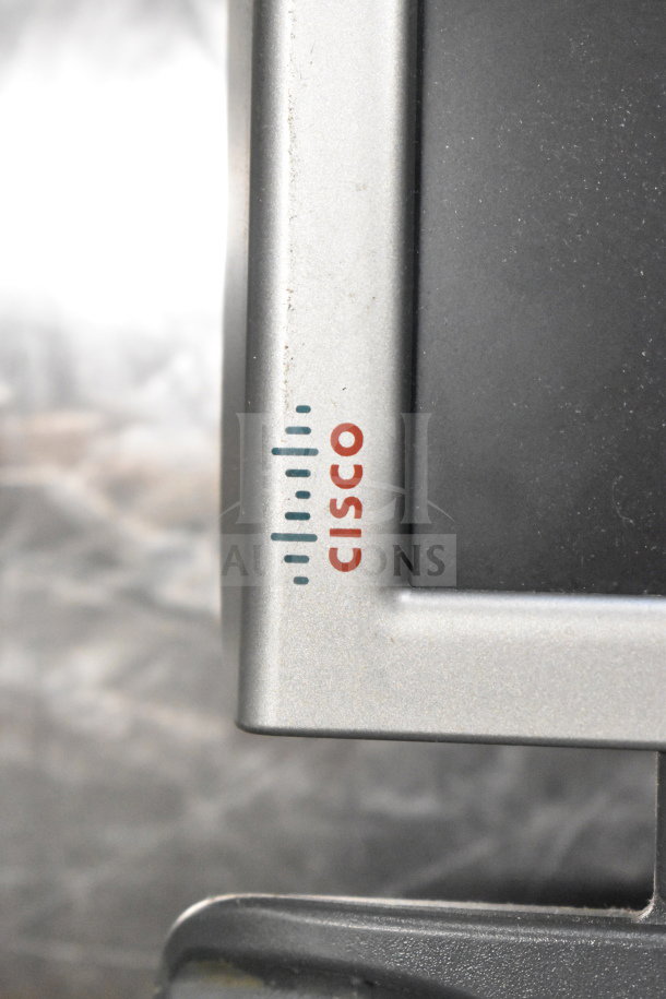 Close-up of Cisco monitor featuring brand logo on a silver bezel. Part of a lot with Toshiba monitors and office equipment.