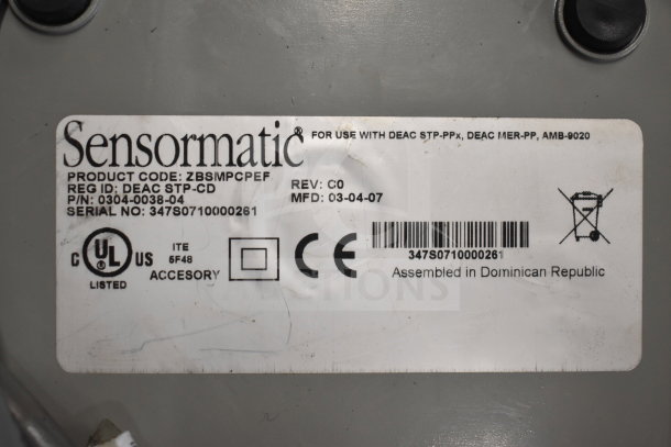 Label on electronic device showing Sensormatic branding, product code ZBSMPCPEF, serial no. 347S0710000261, assembled in Dominican Republic.