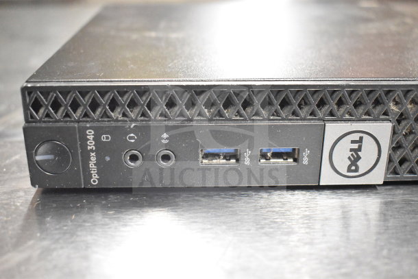 Dell OptiPlex 3040 desktop computer, features USB ports, headphone jack, and power button. Surface shows wear.