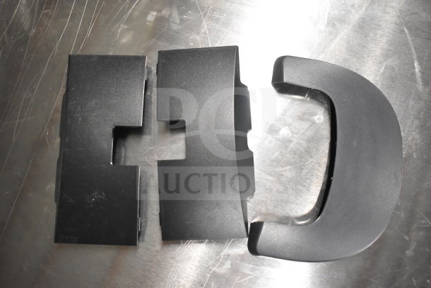 Various black plastic monitor stands on a metal surface. Condition appears used with light scratches.