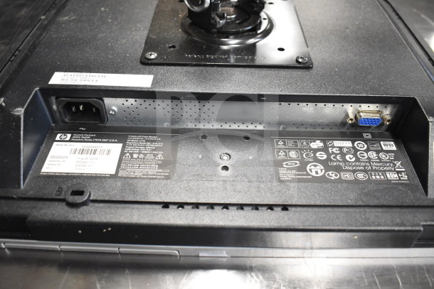 Back view of a Toshiba monitor featuring power input, VGA port, and various compliance labels and warnings. Worn condition.