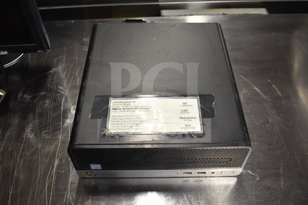 HP ProDesk computer in used condition with a label showing contact numbers for various services. Part of a lot with Toshiba monitors and office equipment.