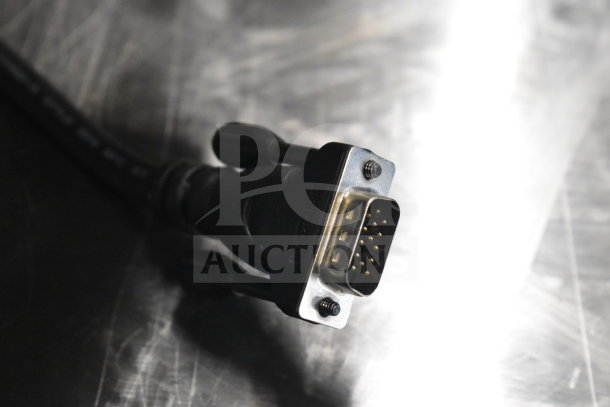 Close-up of a metal connector plug, part of a lot including Toshiba monitors, corded office telephone, receipt printers.