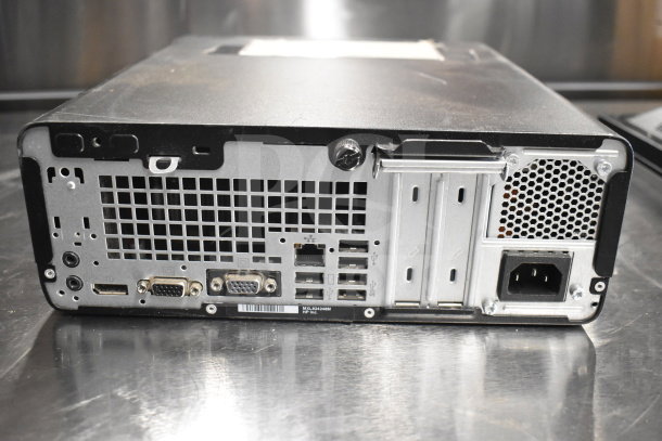 Back panel of a desktop computer with multiple ports and slots visible on a metal surface. Item part of a 15-item auction.