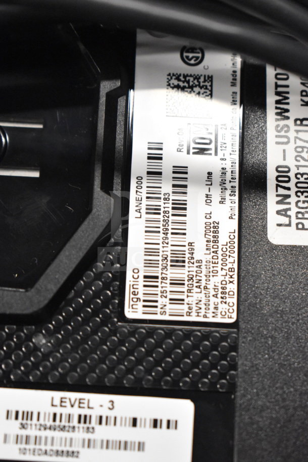 Label close-up on an Ingenico payment terminal, model Lane/7000 SN: 25178730301129495821183; includes certification info.