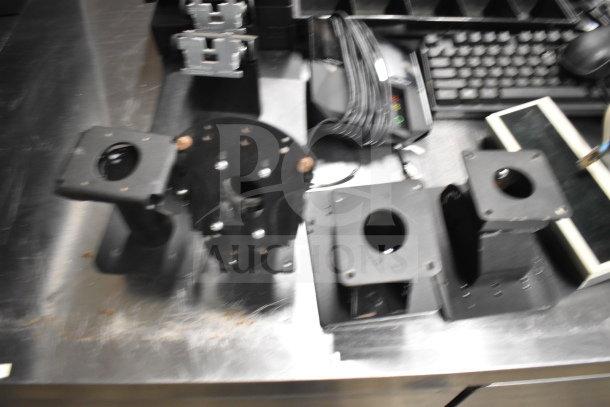 Assorted office hardware including receipt printer, keyboard, credit card reader, and cash drawer insert on a table.