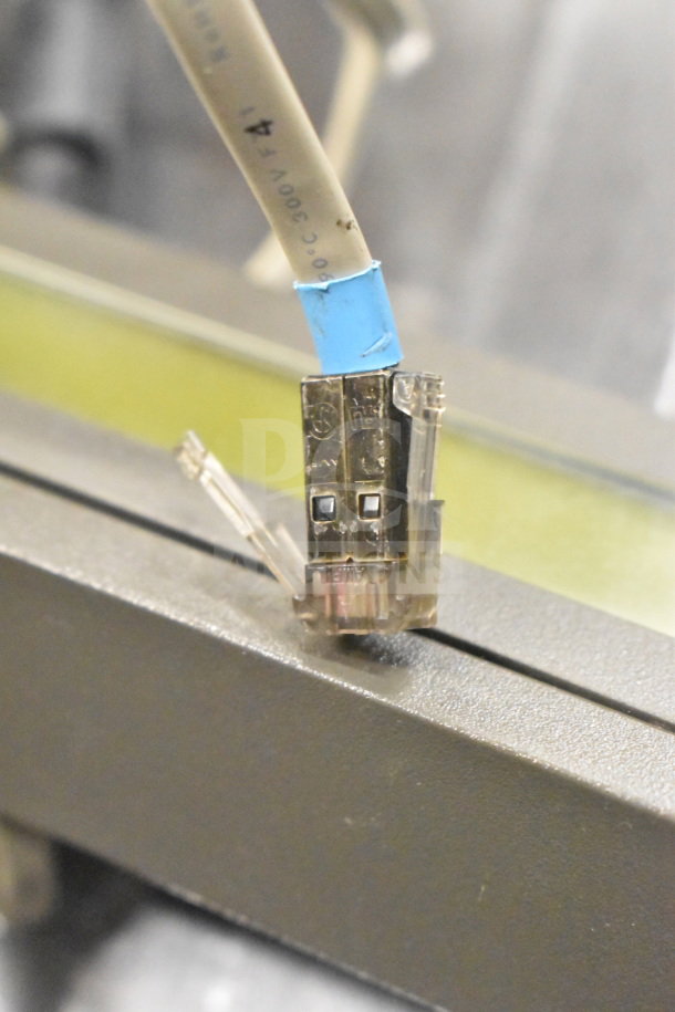 Close-up of a USB connector with visible blue and gray wiring, possibly part of the auctioned technology bundle.