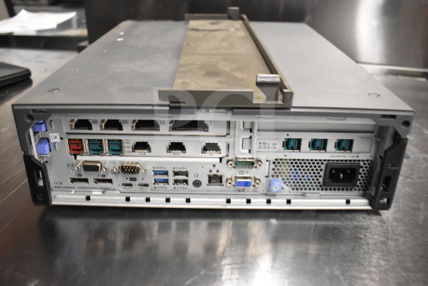 Back view of electronic equipment with multiple ports, suitable for POS systems. Shows connectors and power input.