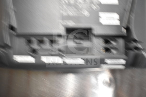 Blurry image showing back of an electronic device with visible ports and labels. Part of a lot including Dell towers, phones, and card reader.