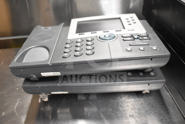 Stacked Cisco corded office telephones with LCD screens and number pads. Used condition. Visible label reads "Cisco."