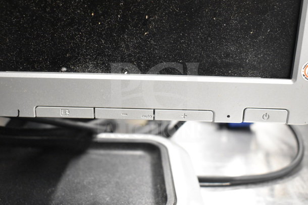 Dell computer monitor buttons in used condition, featuring menu, auto, and power controls. Dust visible on the screen edge.