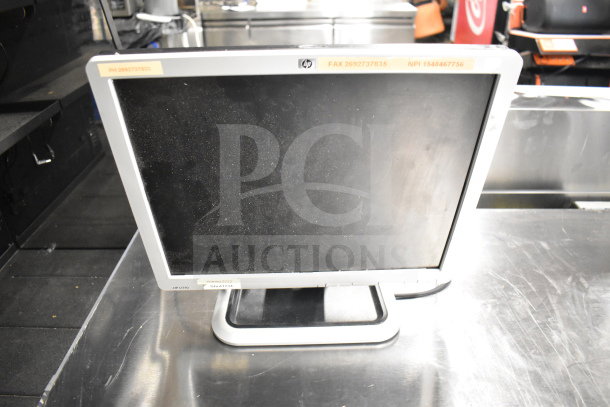 HP L1706 monitor, used condition with visible dust. Labels include FAX, NPI numbers, and serial sticker. Auction lot of 12 items.