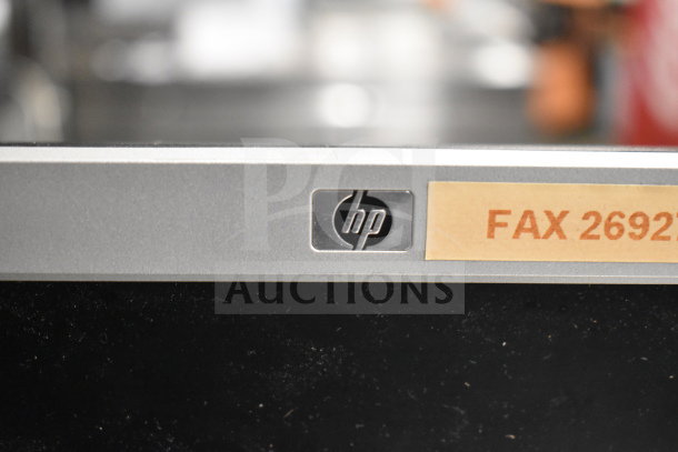 HP monitor with "FAX 2692" label, part of auction lot including Dell computer towers, phones, and card reader.
