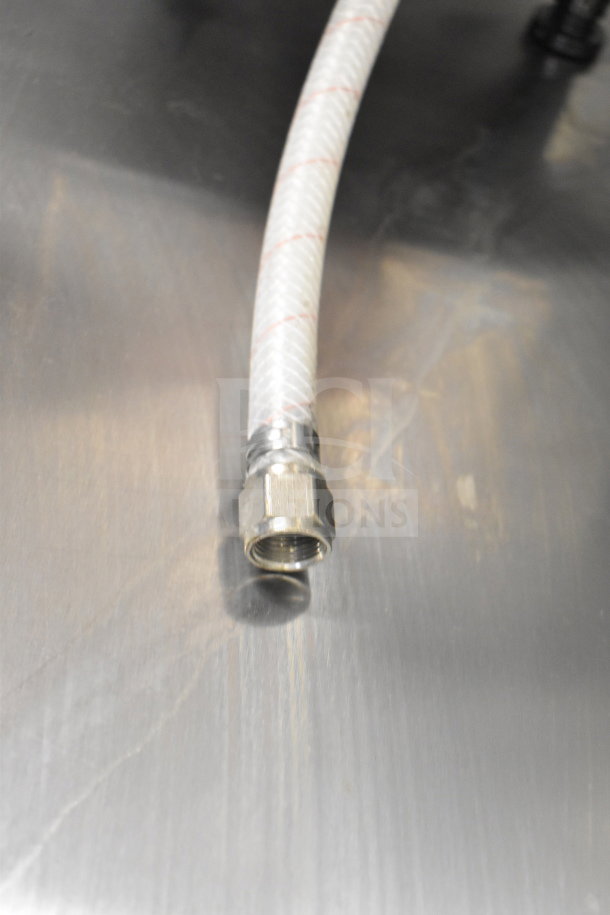 Metallic countertop with a flexible water hose featuring a metallic connector, part of a commercial coffee machine setup.