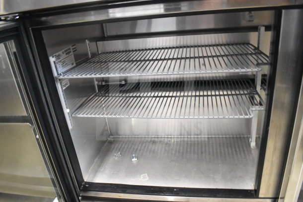True TUC-60G commercial undercounter cooler with two glass doors, stainless steel interior, and adjustable shelves.
