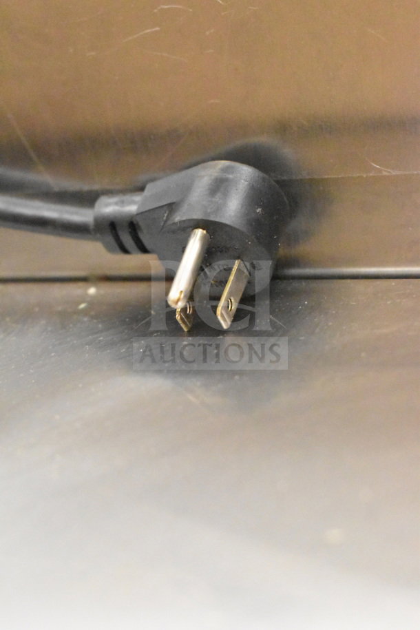 Plug detail of 2017 Delfield D4472N-30M Commercial Prep Table, 115 Volts, 1 Phase, showing the power plug against a metal surface.