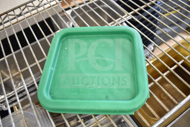 Green plastic lid on wire shelf, marked "CAMBRO" indicating brand; part of a mixed lot with various bins.