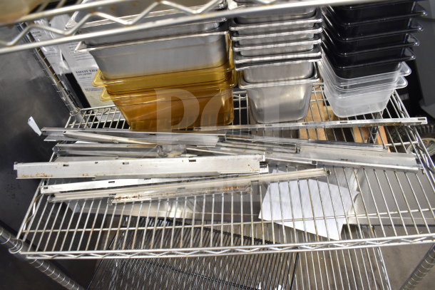 Two-tier lot with assorted metal drop-in bins, metal rails, and trays. Items in used condition on a wire rack.
