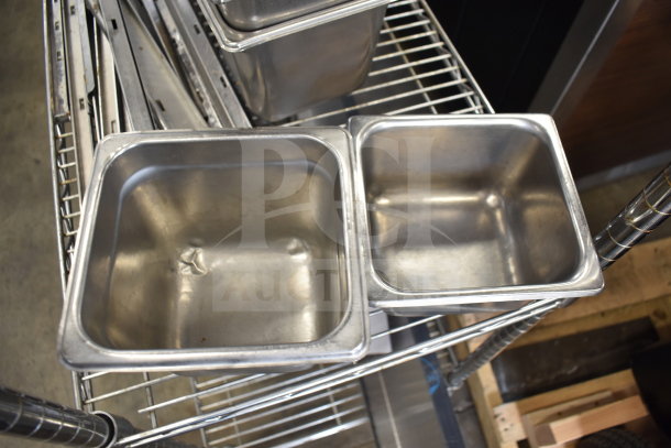 Two-tier lot of stainless steel drop-in bins on a metal rack, used condition, ideal for commercial kitchens.