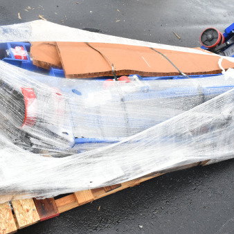 Two brand new Lavex 481XN25DF400 manual pallet jacks with 4,400 lb. capacity, wrapped in plastic on a pallet, showing light scratches and dents.