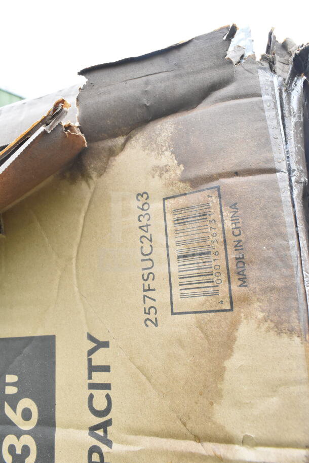 Damaged cardboard box with visible barcode and "257FSUC24363" marking, indicating model of Lavex utility cart inside.