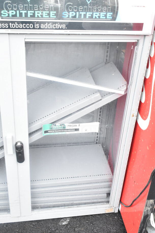 Gray metal 2-door display cabinet merchandiser, features glass doors and adjustable shelves, minor wear visible.