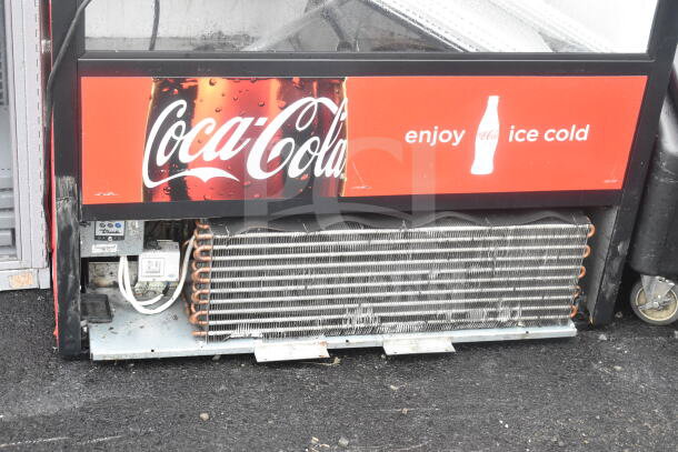 True TAC-48 Commercial Reach-In Merchandiser with Coca-Cola branding. Visible condenser coils; wear on lower panel.