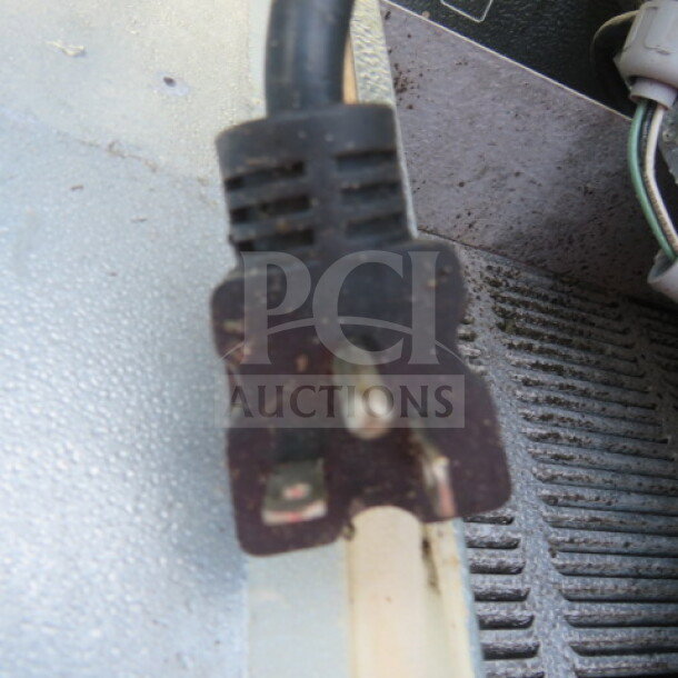 Norlake 4x6 self-contained walk-in cooler power cord plug, showing wear; cooler in working condition before removal.