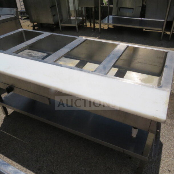Stainless steel 4-well steam table with cutting board and undershelf, in good condition, ideal for commercial kitchens.