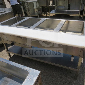 Four-well steam table with cutting board, under shelf; stainless steel construction, good condition, ideal for catering.
