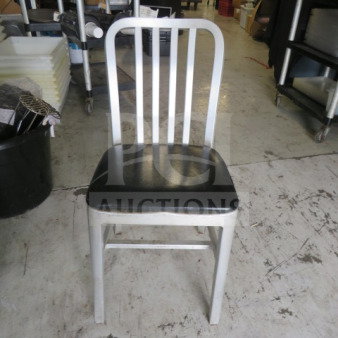 Aluminum chair with black cushioned seat, model 2XBID. Features a vertical slat backrest. Good condition.