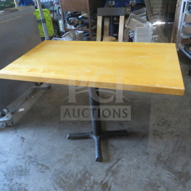 Solid wooden table with a natural finish, pedestal base, measuring 42x30x30 inches. Good condition.
