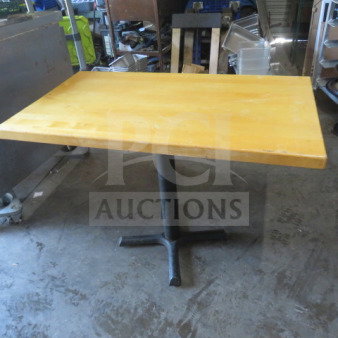 Solid wooden table top on black pedestal base, measuring 42x30x30 inches. Appears to be in good condition.