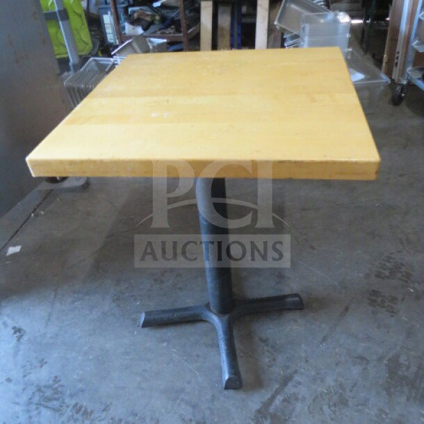 Solid wooden table with a square top on a pedestal base, dimensions 24x24x30 inches, sturdy condition.