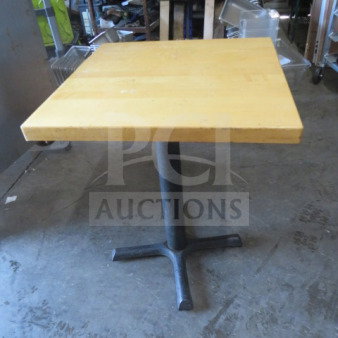 Solid wooden table with a square top on a pedestal base, dimensions 24x24x30 inches, sturdy condition.