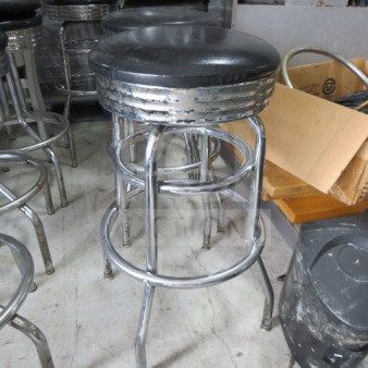 Chrome bar stool with two rings and a black cushioned swivel seat. Moderate wear. Model: 2XBID.
