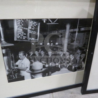 17X21.5 framed vintage-style photo of a crowded diner scene, black and white. Black frame, glass cover.
