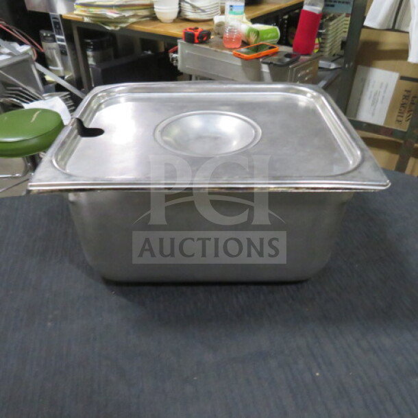 1/2 Size 6 Inch Deep Hotel Pan with Lid, stainless steel, used condition, with slot for utensil on lid.