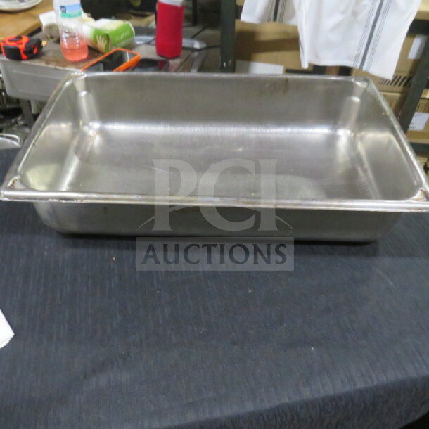 Full-size 4-inch deep stainless steel hotel pan in good condition on a black surface.