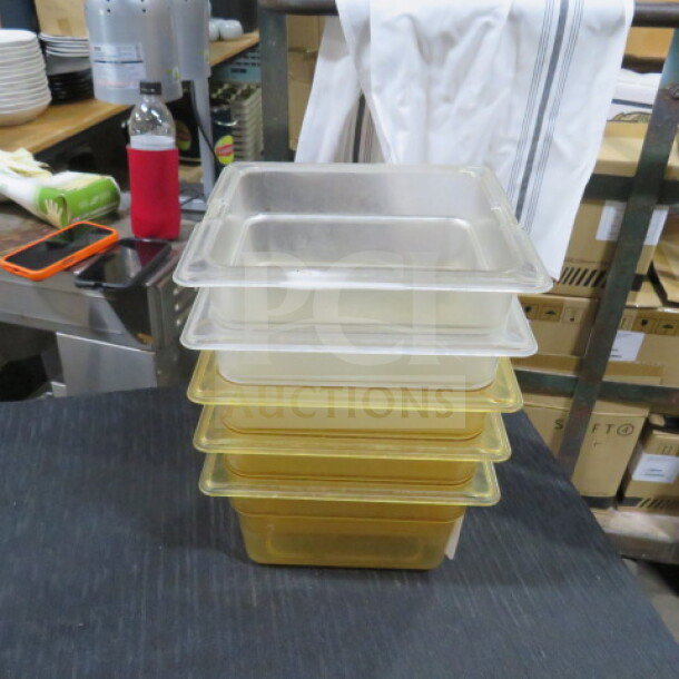 Stack of five 1/6 size, 4-inch deep food storage containers in translucent and yellow hues. Used condition.
