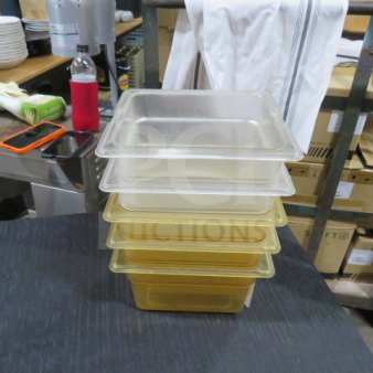 Stack of five 1/6 size, 4-inch deep food storage containers in translucent and yellow hues. Used condition.