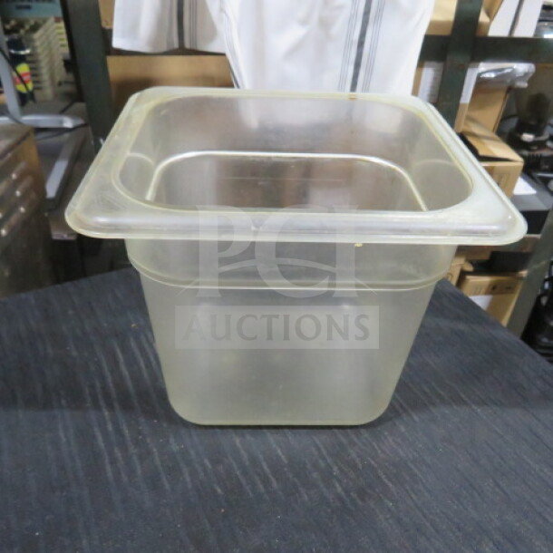Transparent 1/6 size, 6-inch deep food storage container, slightly used. Ideal for kitchen storage. No visible markings.