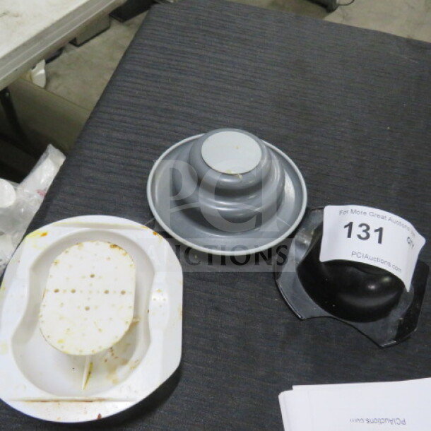Assorted meat tenderizers displayed on a table, including white and gray plastic models with label number "131".