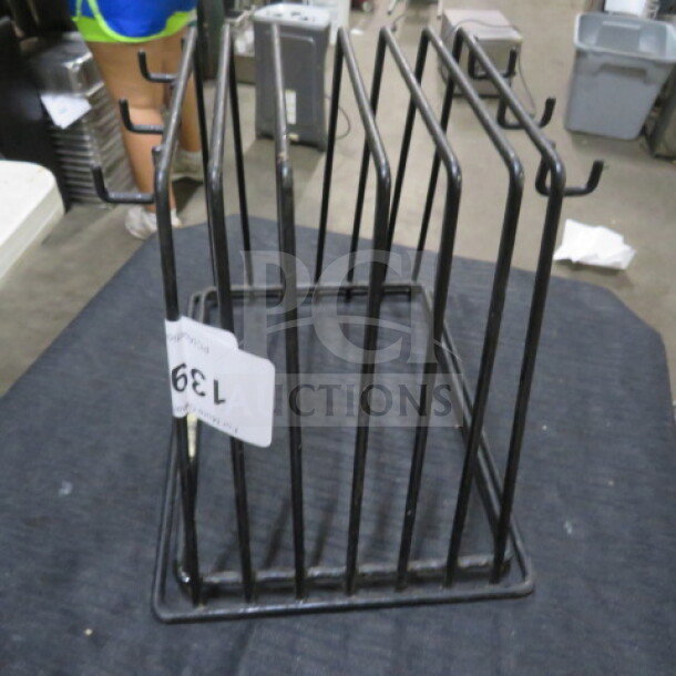 Black metal one pan rack with multiple slots, in good condition. Auction tag labeled "139" attached to the side.