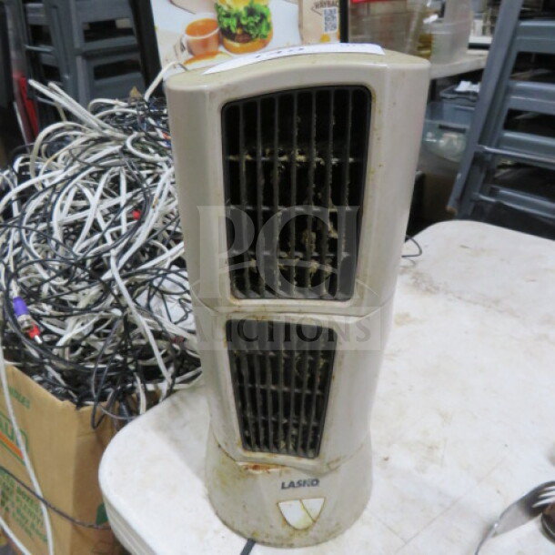 Lasko fan with dual vents, ivory color, evident wear and dust. Lasko logo at base. Suitable for parts or restoration.