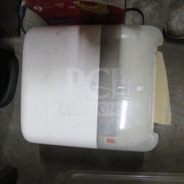 Tork paper towel dispenser, model 2XBID, white, visible scuff marks, wall-mounted with semi-transparent front cover.