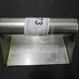 Stainless steel steak weight, rectangular base with handle, minor surface wear, auction label visible.