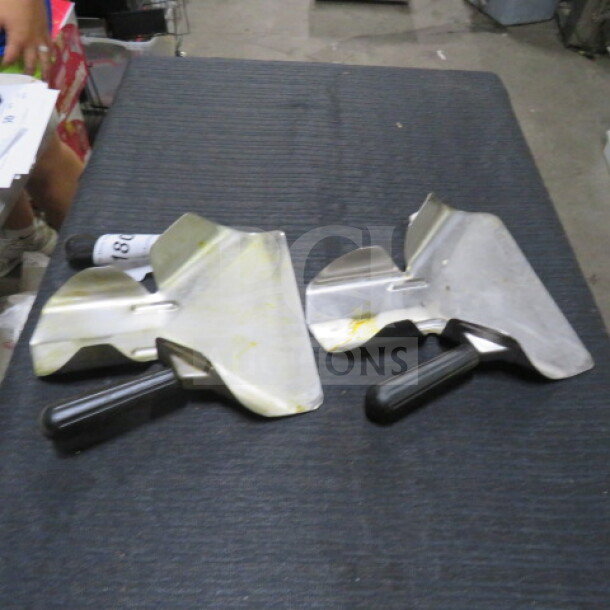 Two metal fry scoops with black handles on a dark surface. Slight wear visible, model 2XBID.