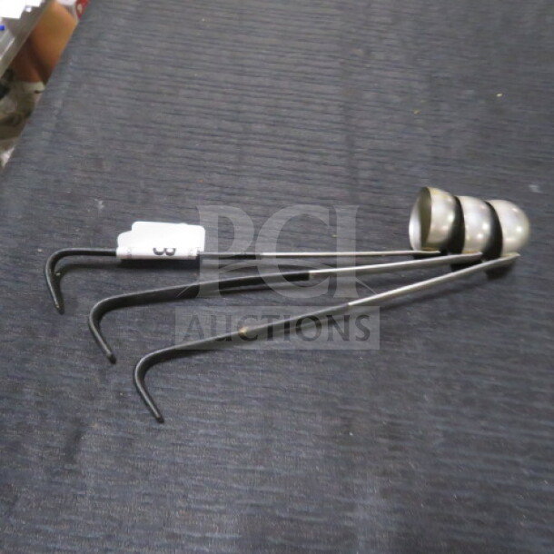 1oz stainless steel ladle, model 3XBID, featuring a polished bowl and long handle. Good condition, slight wear visible.