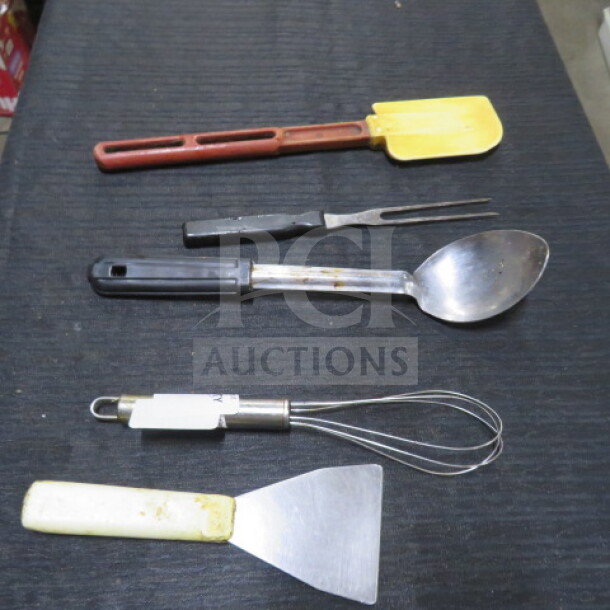 Assorted kitchen utensils including a spatula, fork, spoon, whisk, and scraper on a black surface. Various conditions.